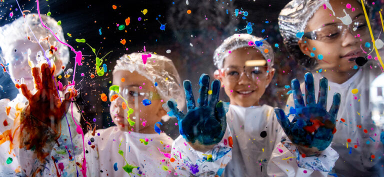 Kids hand paint behind glass wall at Pinspiration