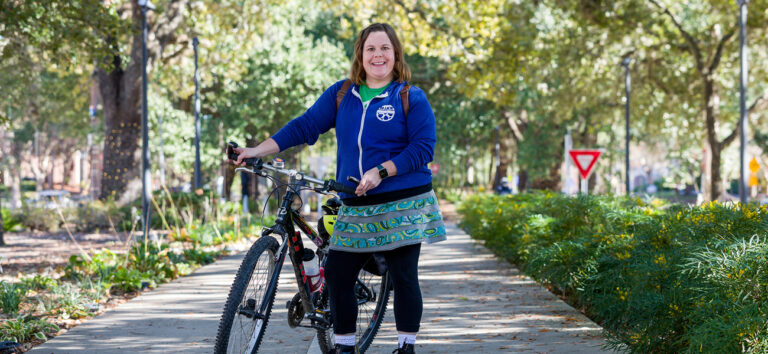 This is a photo of Lynley Farris standing by her bike. People to watch - community